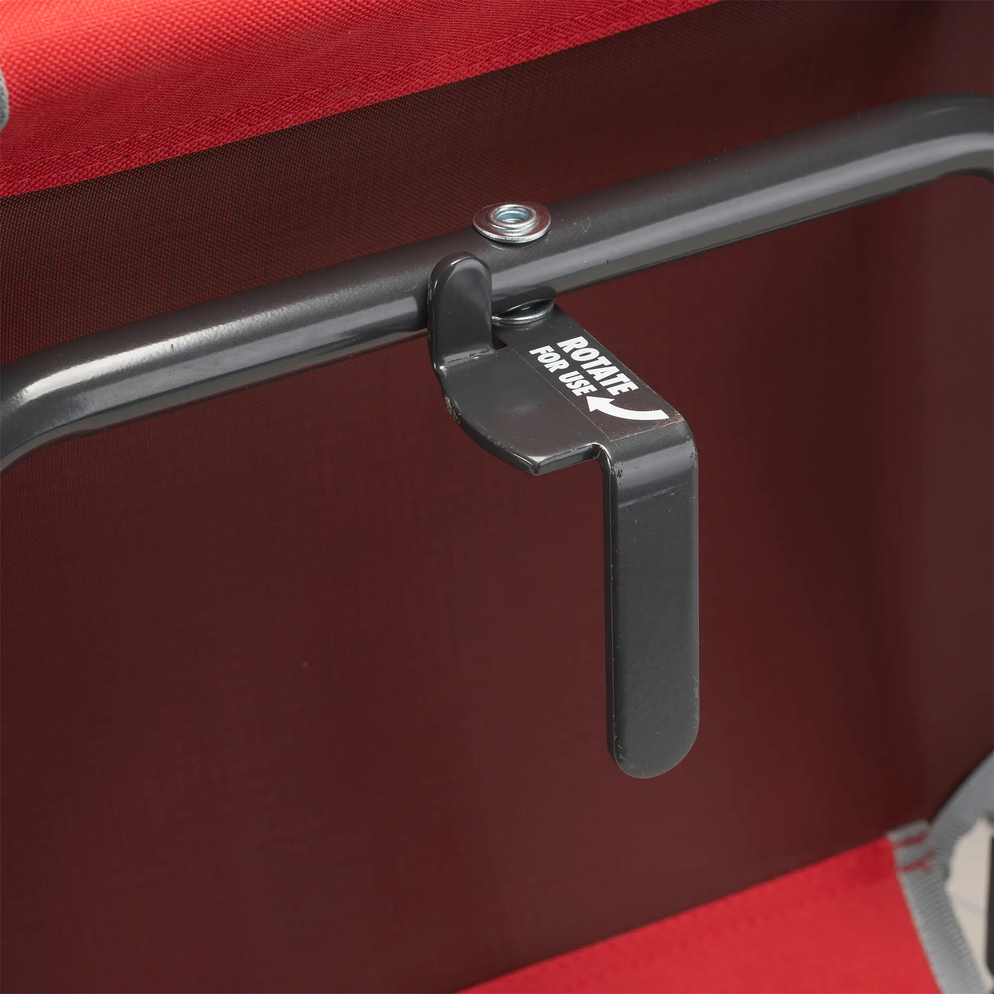 An up-close of the l-hook underneath the red/gray big comfort stadium chair with armrests.