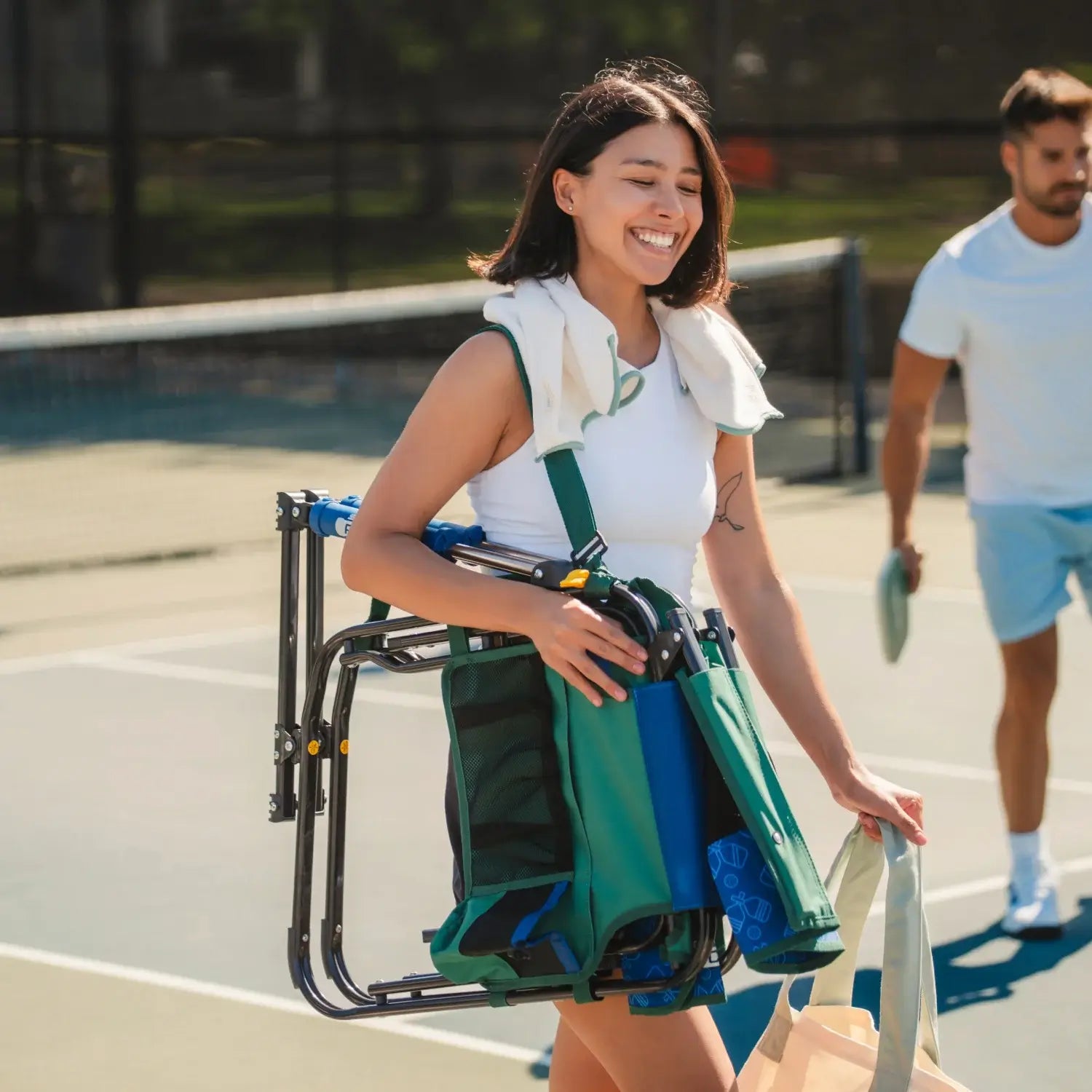 A woman carrying the pickleball stowaway rocker with a shoulder strap.