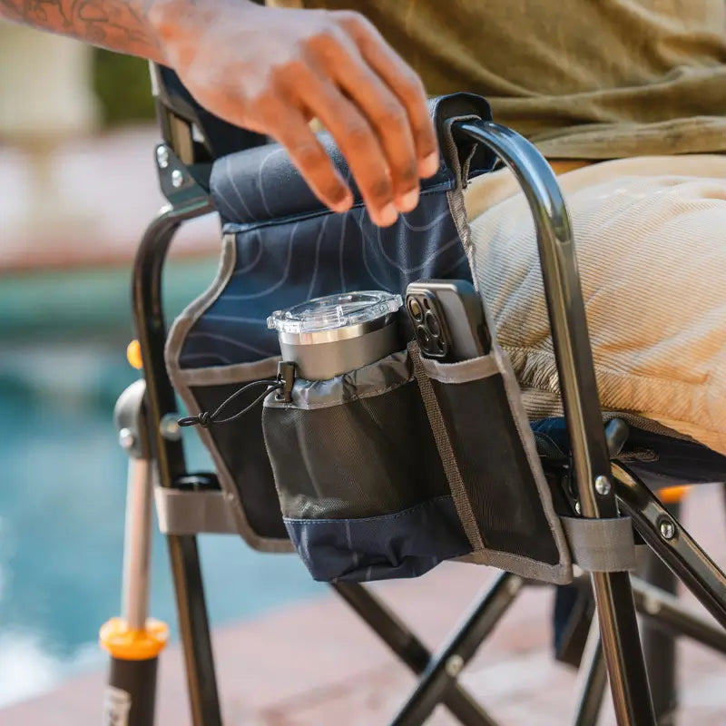 Close-up of Navy Topo Stowaway Rocker side storage pockets with a lantern and phone.