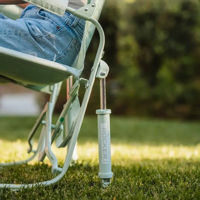 Side view of the Stowaway Rocker’s spring-loaded leg and rocking mechanism on grass.