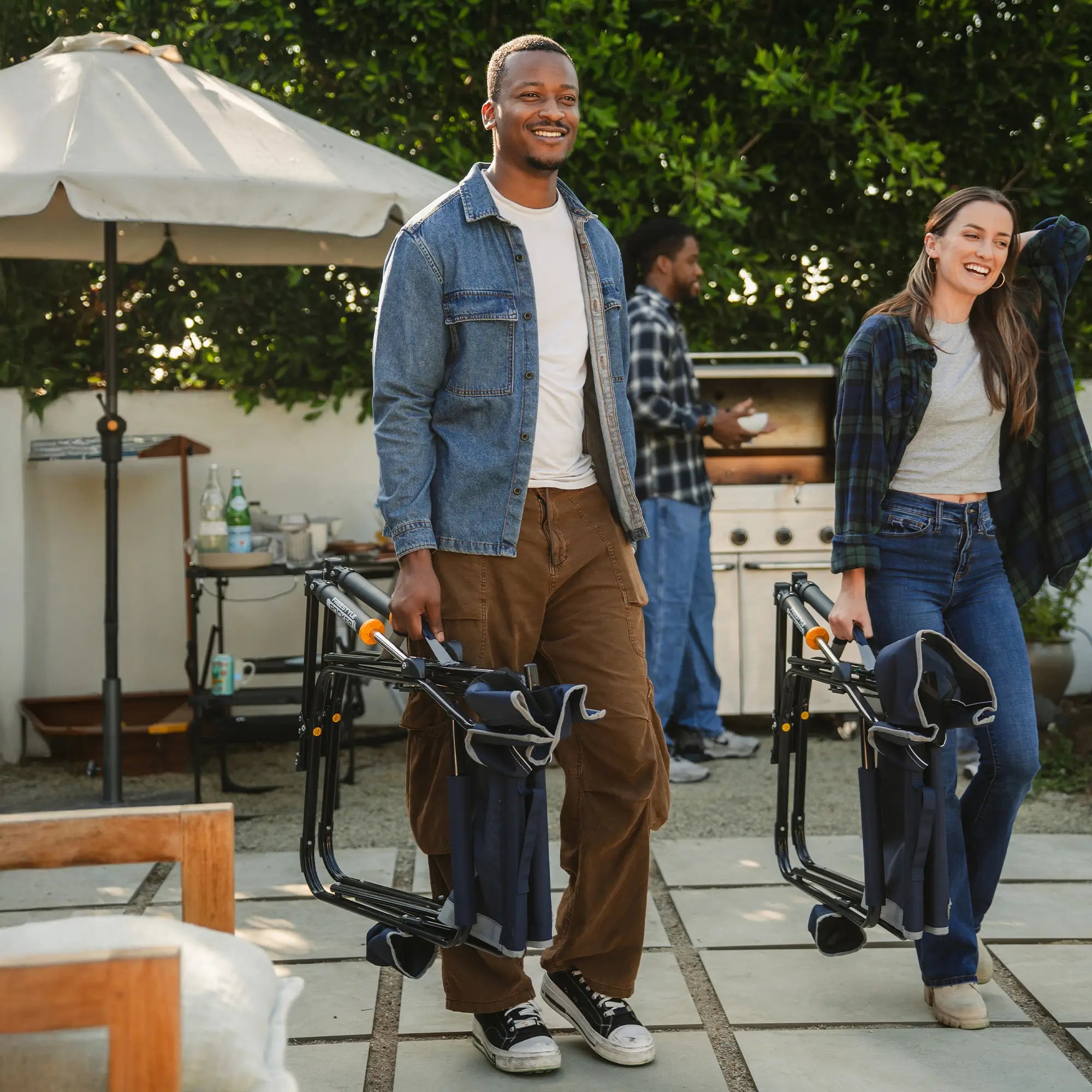Two people laughing and walking while carrying their indigo freestyle rockers using the integrated carry handle. 