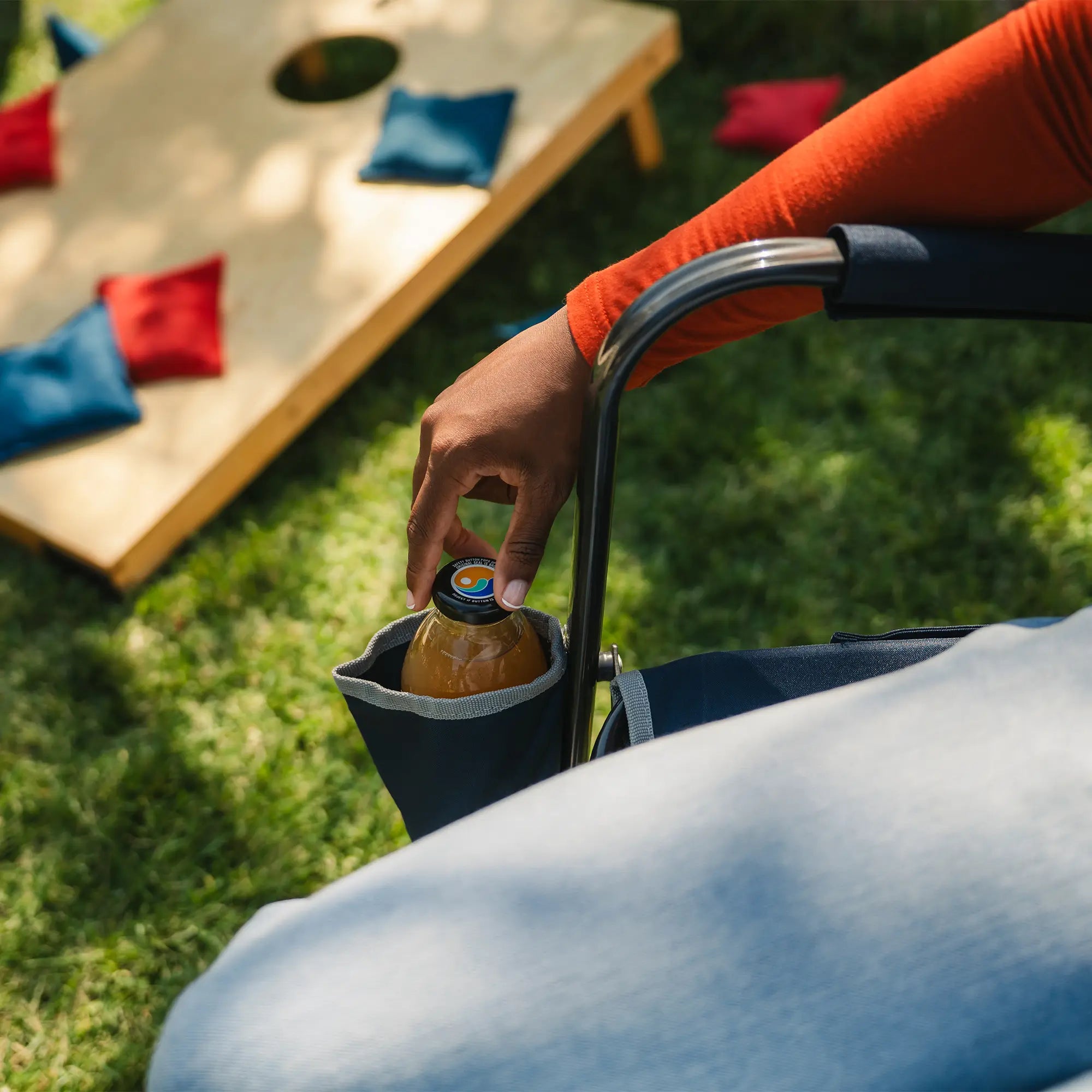 A woman reaching for her drink in the indigo freestyle rockers integrated cup holder. 