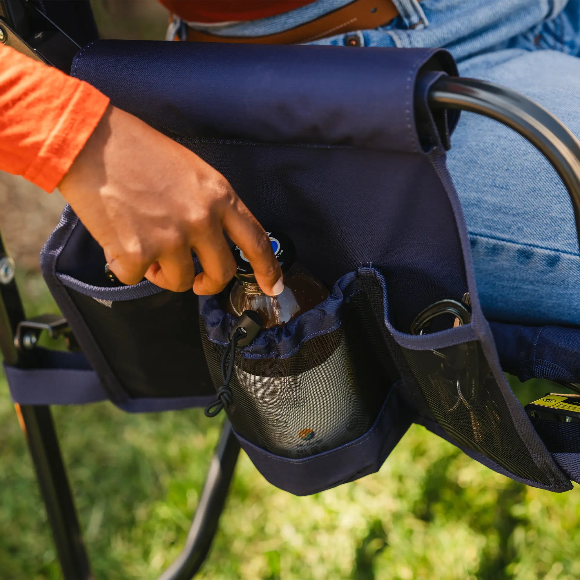 An up-close angle of the side pocket on the blue tailgater stowaway rocker showing a phone pocket and drink holder. 