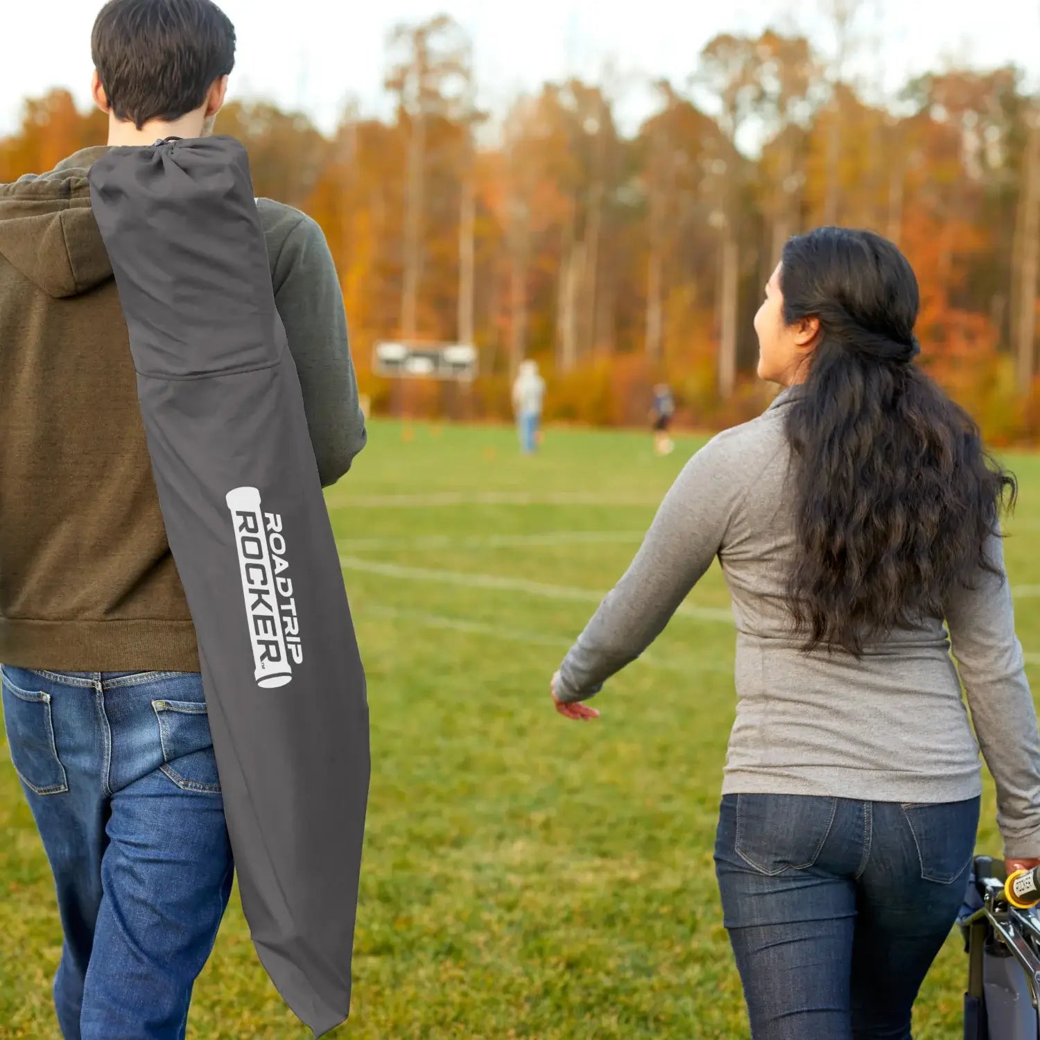 A couple carrying the roadtrip rocker inside a bag. 